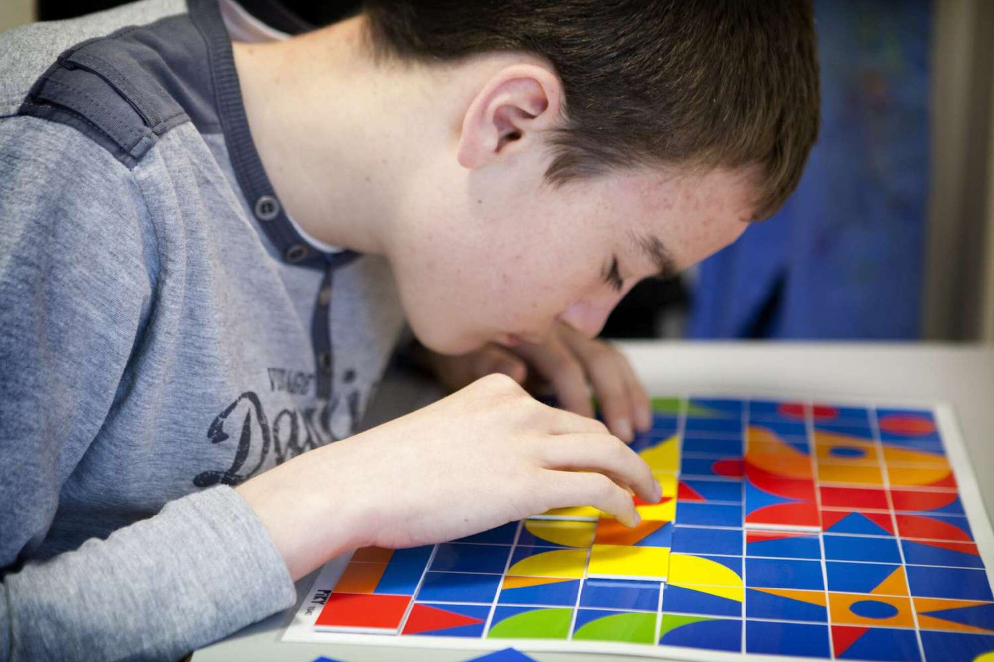 A child solving a colorful jigsaw puzzle.